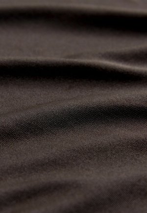 Tmavohnedá tkanina s hladkým, textúrovaným povrchom a jemným vzorom tkania, zobrazujúca jemné záhyby a rôzne odrazy svetla.