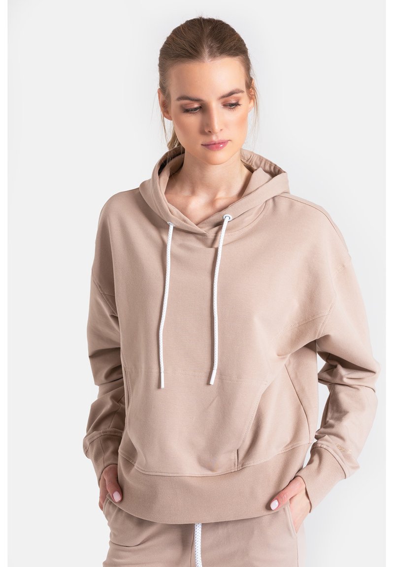 Beżowa bluza z kapturem, z przednią kieszenią kangurką, sznurkiem w kapturze, ściągaczami na rękawach i u dołu. Miękki materiał o luźnym kroju.