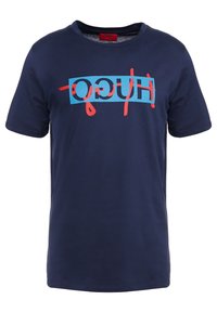T-shirt in cotone blu navy con maniche corte, caratterizzata da un audace design grafico con testo in turchese e rosso che recita "HUGO" sulla parte frontale.