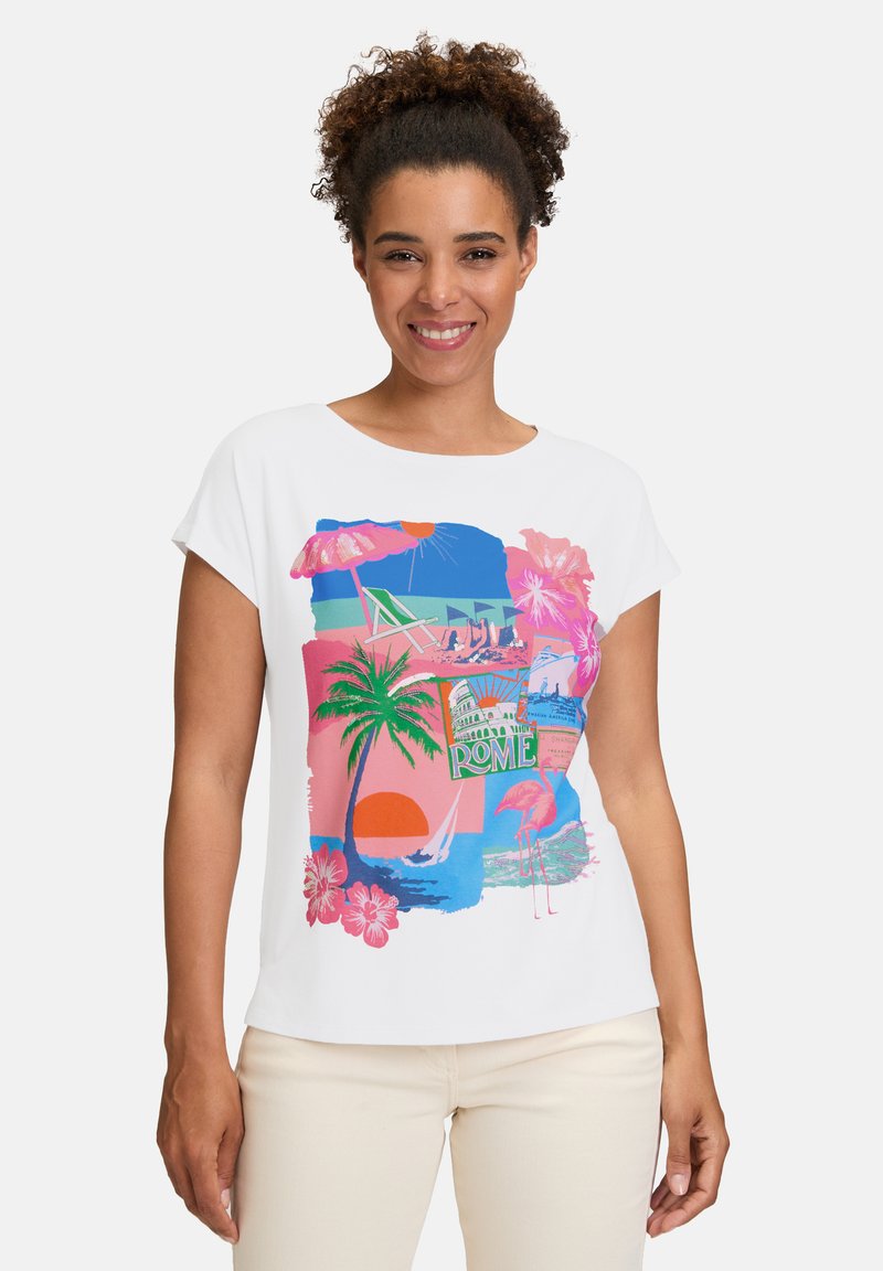 Bílé tričko s krátkým rukávem, které má pestrou tropickou grafiku zahrnující palmy, západ slunce a plameňáka s textem "ŘÍM".
