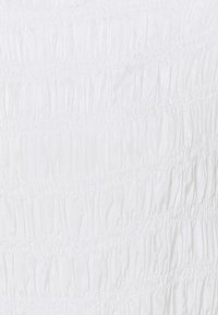 Tessuto bianco arricciato con pieghe orizzontali. Texture morbida con una lucentezza uniforme, creando un effetto a onde sulla superficie.