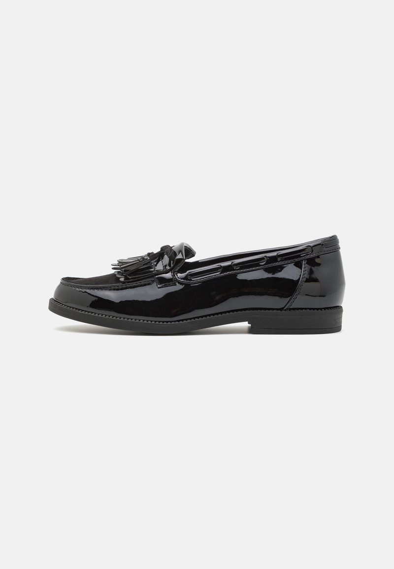 Mocassin en cuir verni noir avec détail de pompon, talon bas et bout arrondi, présenté en profil latéral sur fond blanc.