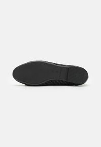 Suola di scarpa nera con un motivo testurizzato e finitura liscia. Caratterizzata da una forma arrotondata, bordi rinforzati e segni antiscivolo. Taglia 37.