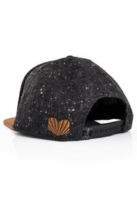 Black textured cap with a speckled design, brown suede visor, and an embossed brown shell emblem on the back. Snapback closure visible.