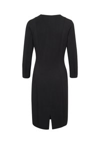 Robe noire mi-cuisse avec manches longues, taille ajustée et petite fente arrière sur fond blanc.