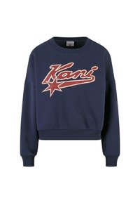 Námořnická modrá zkrácená mikina s dlouhými rukávy, která má na přední straně opotřebovaný červenobílý grafický design "Kani" a vzor hvězdy.