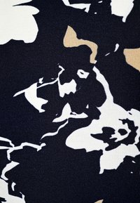 Navy fabric with a floral pattern in white and beige tones. Smooth texture, close-up view highlighting the design details.