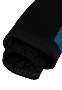Manche de veste noire avec poignet élastique, présentant une bande d'accent bleue et un tissu lisse et texturé, montrant la doublure intérieure du poignet.
