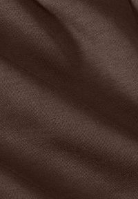 Tissu doux et texturé dans une riche couleur marron, présentant un subtil motif de tissage et des plis doucement drapés. Idéal pour diverses applications textiles.