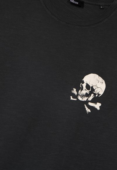 Maglietta nera in cotone con design bianco di teschio e ossa incrociate sul lato sinistro del petto; tessuto liscio, collo rotondo.