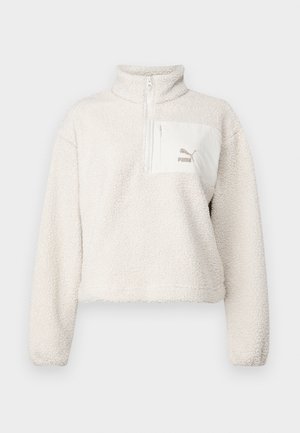 Heled värvi fliispullover kõrge kraega ja poolsiiliga. Omab esipocketit ja väikest logo taskul. Pehme tekstuur.