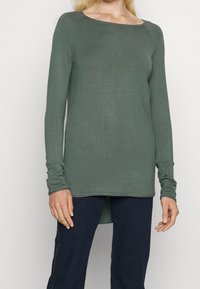 Grünes Langarmshirt aus weichem Stoff, mit rundem Ausschnitt, schmaler Passform und leicht verlängertem Rückensaum.