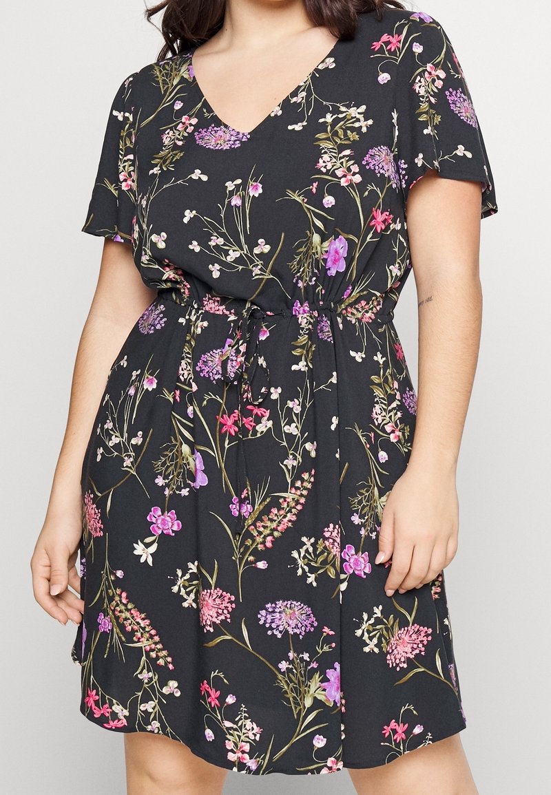 Short floral dress with a V-neck and short sleeves. Made of lightweight fabric, featuring a black background with colorful flower patterns.