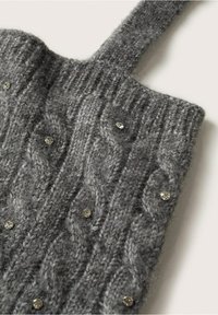 Sac en laine grise tricotée avec un motif torsadé, orné de petits strass. Le sac dispose d'une bandoulière solide pour le transport.