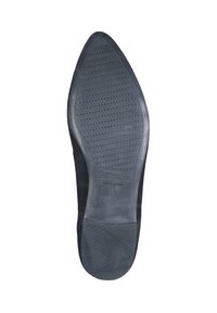 Semelle de chaussure en caoutchouc noir avec une surface texturée, arborant un logo et fabriquée au Portugal. La forme est effilée au niveau des orteils.