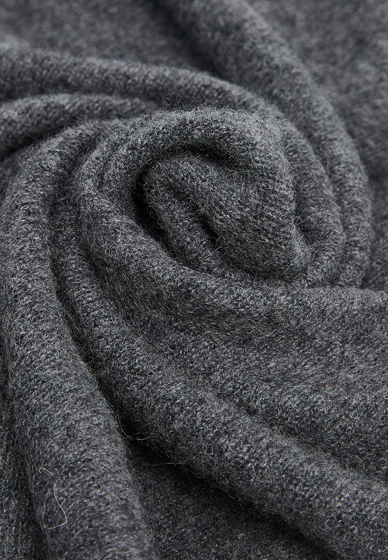 Weiches, dunkelgraues Wollgewebe mit einer samtigen Textur, eng zu einem spiralförmigen Muster eingerollt.