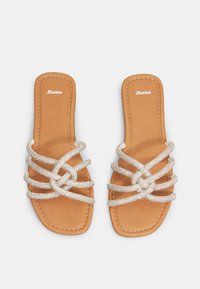 Infradito in finta pelle marrone con cinturini incrociati in metallo argentato e una soletta imbottita. Presenta un semplice dettaglio di cucitura.