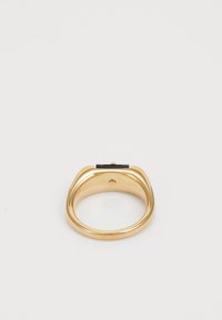 Gouden ring met een gladde, gepolijste afwerking en een platte, rechthoekige zwarte accent bovenaan. Heeft een afgerond bandontwerp.