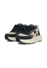 Des baskets arborant un schéma de couleurs noir et beige, fabriquées en suède et en mesh, avec des accents texturés et une semelle épaisse au design structuré.