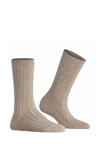 Calze a coste beige realizzate in materiale morbido con una finitura testurizzata. Presentano una lunghezza fino al polpaccio e aree della punta e del tallone rinforzate.