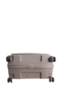 Hard-shell suitcase in light beige with textured ridges, dual silent wheels, and a top zipper closure. Compact rectangular design.