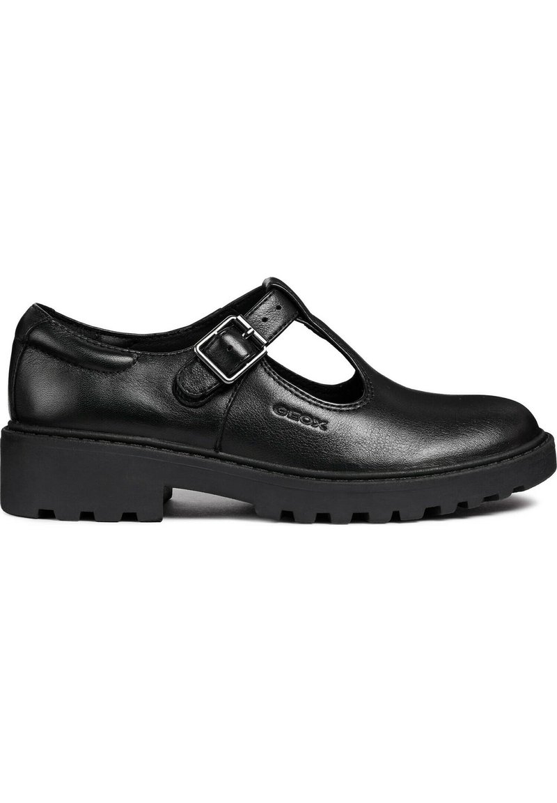 Zapatos Mary Jane de cuero negro con un diseño recortado, hebilla ajustable y una suela de goma gruesa con un patrón de banda de rodadura.