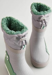 Szare wodoodporne buty z teksturowaną powierzchnią, zielonym puszystym wyściółką i zielonym wzorem żaby z boku, z zaciąganym zapięciem u góry.