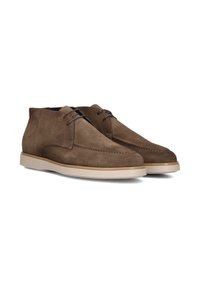 Bruine suède chukka laarzen hebben een ronde neus, gestikte details, donkere veters en een contrasterende lichte rubberen zool.