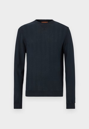 Pull bleu marine à manches longues, motif chevrons texturé, encolure ronde, poignets et ourlet côtelés. Matière en mélange de coton.