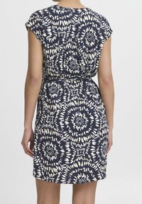 Mörkblå klänning med ett vitt spiralmönster, korta ärmar, rynkad bak och avskuren midja, tillverkad av ett lätt material.