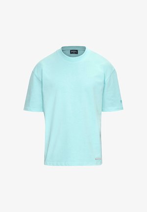 Világoskék pamut póló rövid ujjakkal, kerek nyakkal és diszkrét logóval az alsó bal oldalon. Simma textúra, laza dizájn.