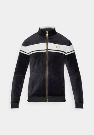 Schwarze Samt-Jacke mit Reißverschluss und hohem Kragen, weißen Streifen über der Brust, goldenen Beschlägen und Logodetail. Rippbündchen und Saum.