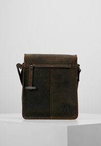 Borsa a tracolla in pelle marrone con chiusura a pattina, tasca frontale con zip e tracolla regolabile. Presenta un logo triangolare sulla parte anteriore.