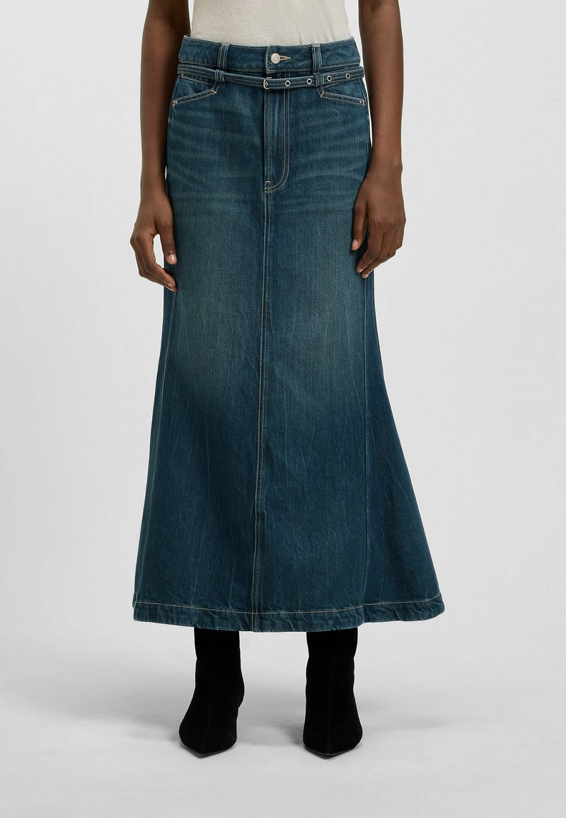 Tummansininen farkkumallinen maksihame liehuvilla saumoilla, jossa on napitus, vyön lenkit ja sivutaskut. Yhdistetty mustiin nilkkureihin.