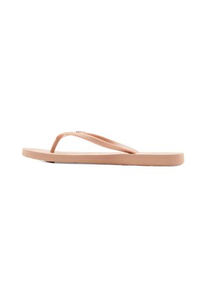 En enkel lys brun gummi flip-flop sandal med teksturert såle og chevron-mønstrede stropper på en hvit bakgrunn.