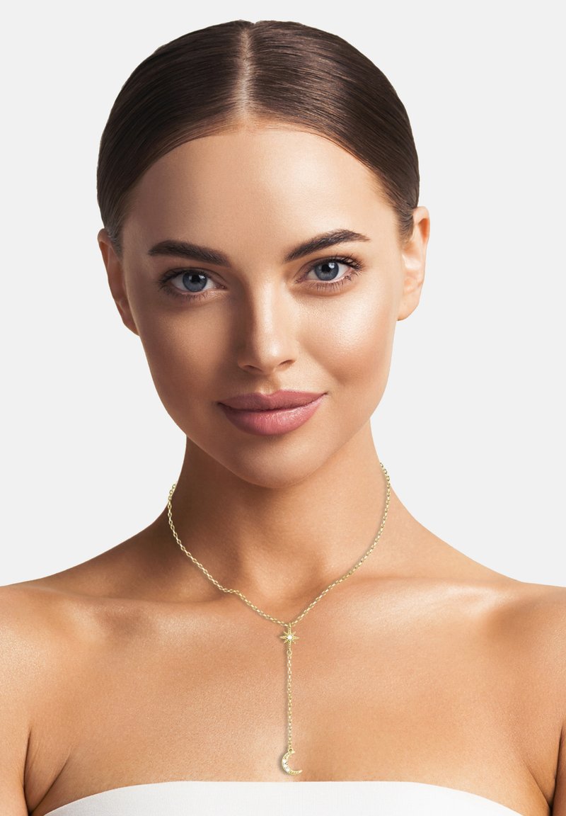 Guldkæde med en stjerne og en halvmåne vedhæng, delikat design, glat tekstur og justerbar længde.