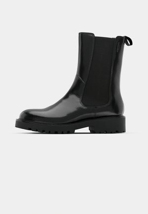 Melnas potītes zābakus, kas izgatavoti no spīdīga materiāla, ar elastīgām sānu daļām, cilpu, un biezu, izturīgu zoli ar rakstu detalizāciju.