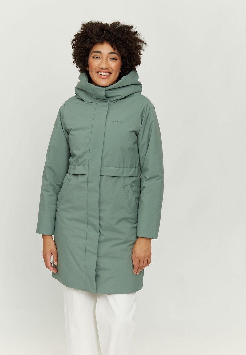 Long, green puffer coat with a high collar, wide hood, and front pockets. Smooth texture, cinched waist detail, and minimal branding.