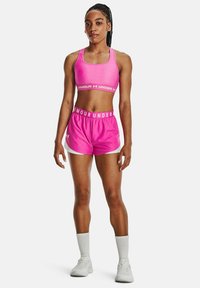 Conjunto de sujetador deportivo y pantalones cortos en color rosa con acentos blancos. Fabricado en tela elástica. Presenta una banda con logo en los pantalones y en el sujetador.