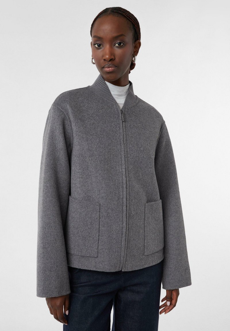 Graue Wollmischjacke mit hohem Kragen, durchgehendem Reißverschluss und zwei Vordertaschen. Verfügt über lockere Ärmel und eine weiche Textur.