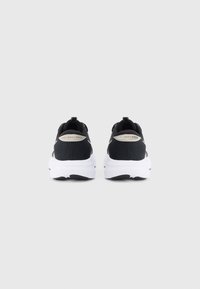 Scarpe sportive nere con tomaia in rete e suole bianche imbottite. Presentano un dettaglio con logo sul tallone e un'etichetta per indossarle facilmente.