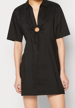 Vestido negro de manga corta con cuello, corte en forma de chave en la parte delantera y detalle recogido en la parte inferior. Fabricado en una tela suave y ligera.