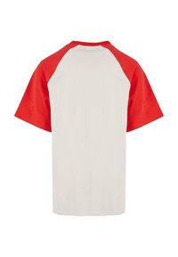Cotton t-shirt with short red raglan sleeves. White body, crew neck, and straight hem. Soft texture, no visible patterns or hardware.