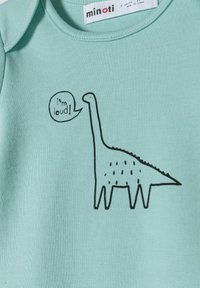 Svijetloplava pamučna bodi s crnim grafičkim dizajnom dinosaura i natpisom "Glasan sam!" unutar govorne oblačiće. Kratki rukavi i okrugli izrez.