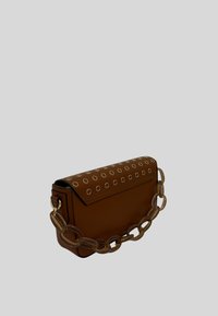 Borsa a mano in pelle marrone con patta pieghevole, decorata con occhielli circolari in argento. Presenta una robusta catena trasparente come tracolla.