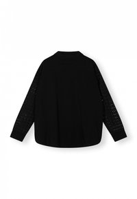Zwarte shirt met een effen stof op het lichaam en geperforeerde details op de mouwen. Standaard kraag en knoopmanchetten.