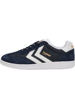 Marineblaue und weiße Hummel Sneaker mit Schnürverschluss, weißen Chevron-Streifen, Wildleder-Akzenten und einer strukturierten weißen Gummisohle.