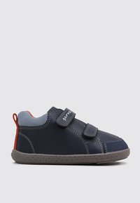 Zapato infantil de color azul marino con acentos en gris y rojo, dos tiras de Velcro, forma redondeada, suela de goma texturizada y detalles cosidos.
