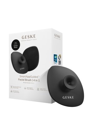 Brosse faciale ovale en silicone noire avec fixation par ventouse et surface texturée, à côté d'un emballage blanc étiqueté "GESKE SmartAppGuided Facial Brush 4 in 1."