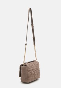 Borsa a tracolla taupe imbottita con una forma strutturata, caratterizzata da una morbida texture in suede, una catena e una tracolla regolabile, con un accento in metallo nero.